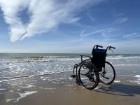 Provider Direct homepage image. A Wheel chair in an empty beach
